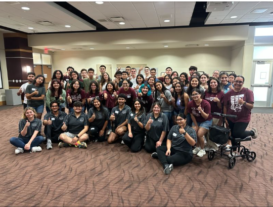 GTF Mentors and students at their 2023 new GTF student orientations. The mentors are in the front row wearing matching gray polos. The are also doing the A&M Gig'em hand sign.